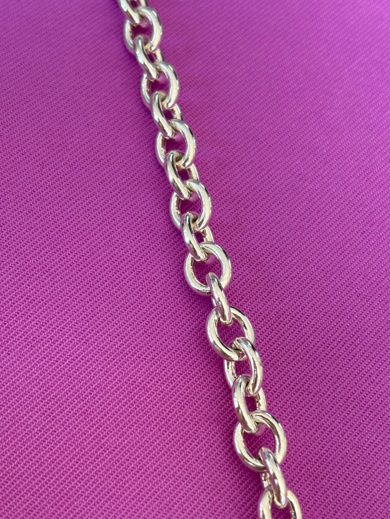 Sterling silver chain on a purple fabric background