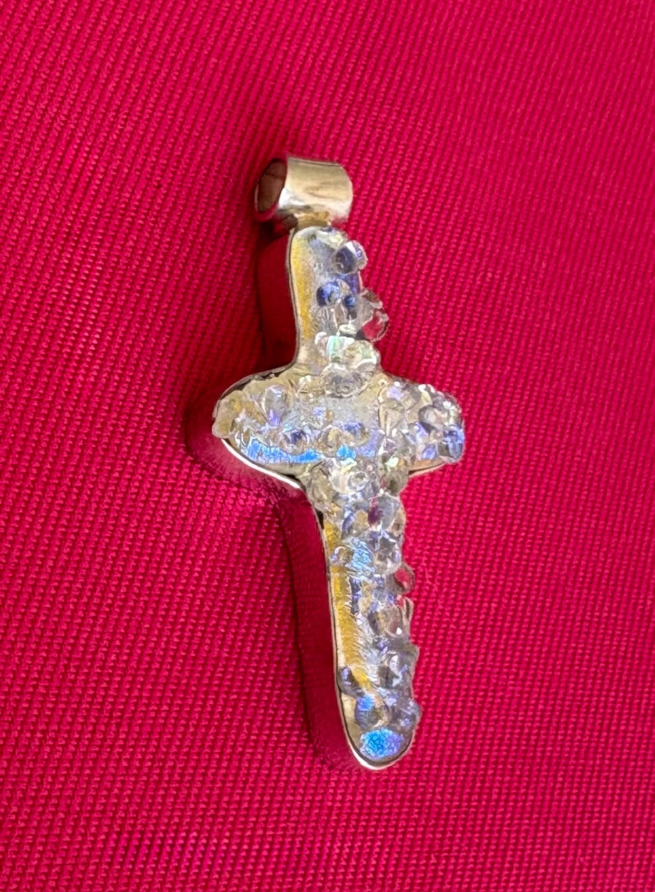 Glass cross pendant on a red background