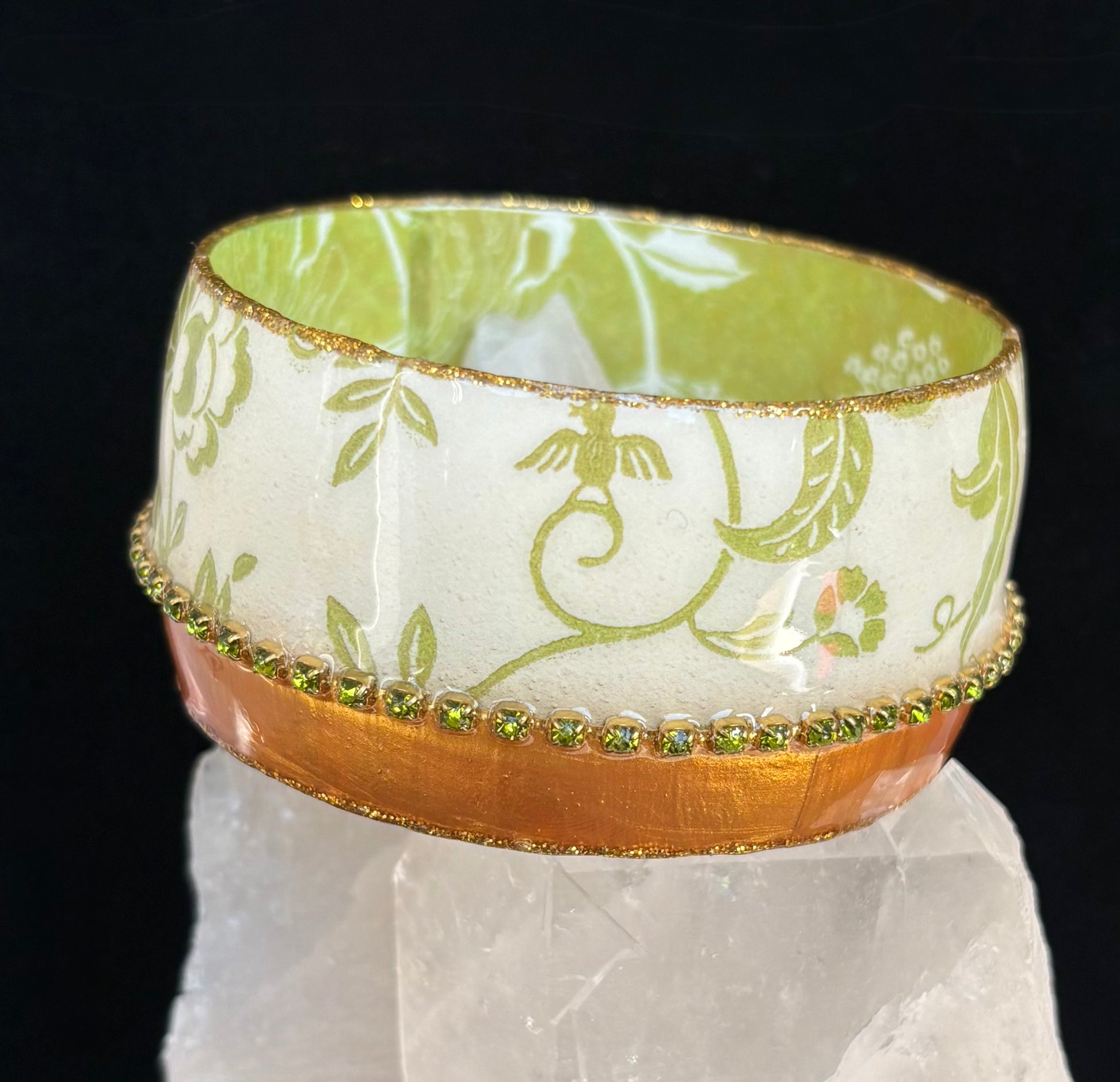 Decorative bangle with floral pattern on a reflective surface