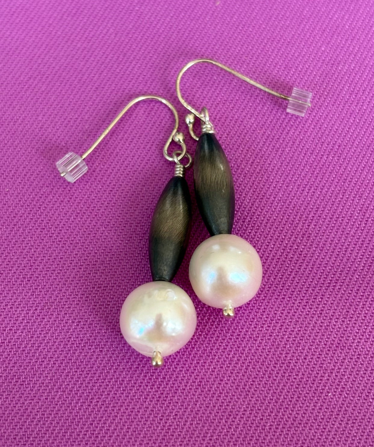 Pair of earrings with Navajo Silver and pearls on a purple background