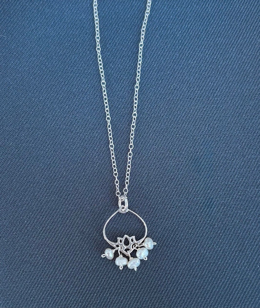 Silver necklace with a pendant on a blue textured background