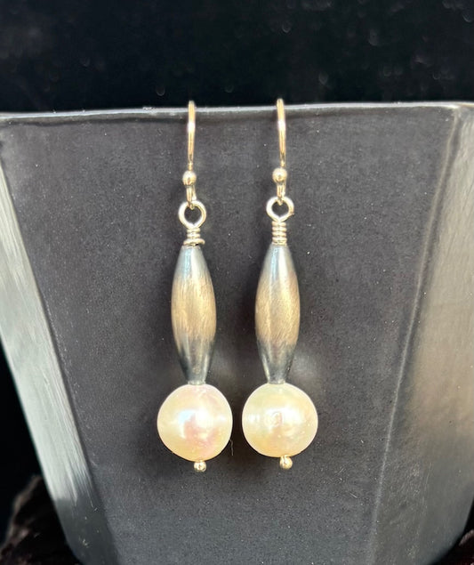 Pair of pearl earrings on a dark background