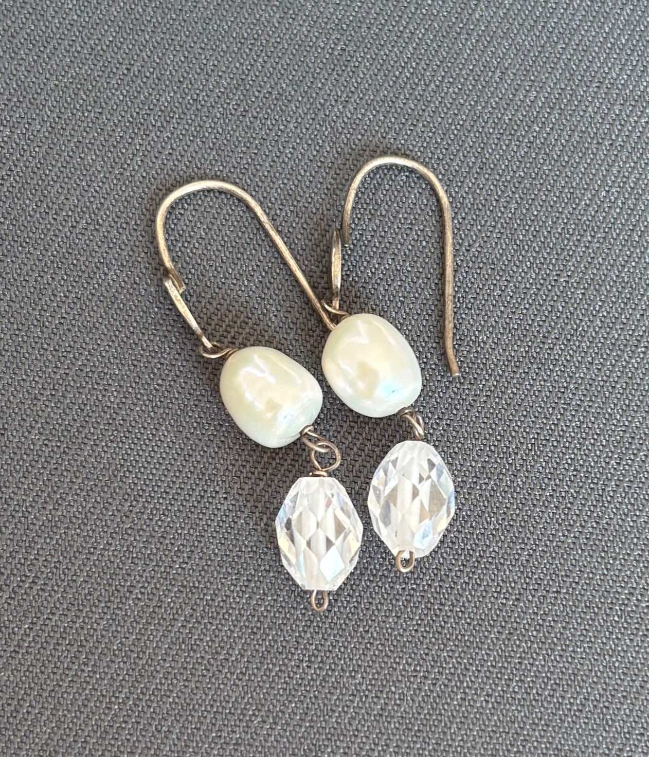 Pair of earrings with pearl and crystal beads on a gray background