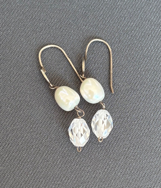 Pair of earrings with pearl and crystal beads on a gray background