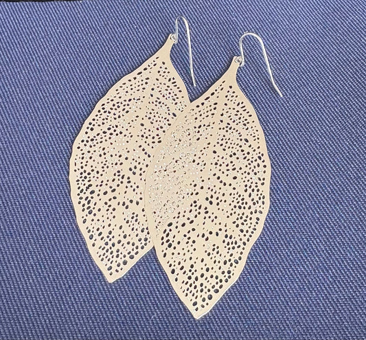 Jolie Esprit  leaf-shaped earrings on a blue textured background