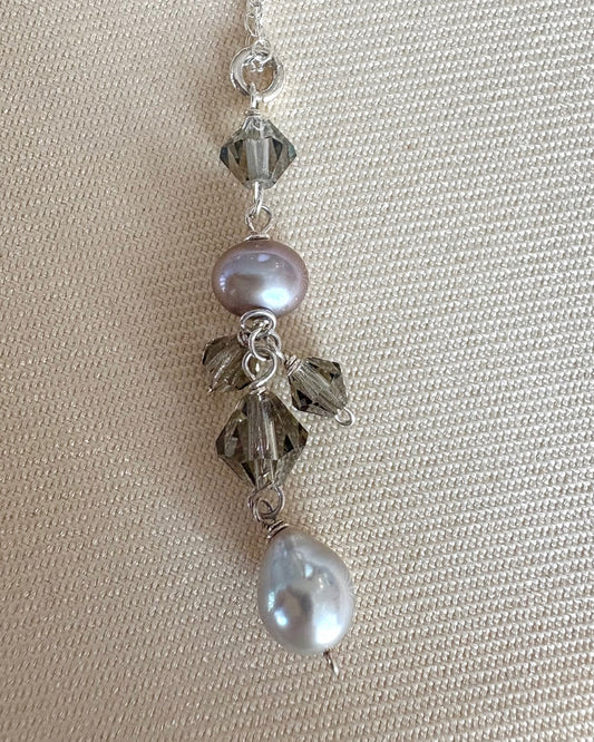 Necklace with pearls and crystals on a beige fabric background