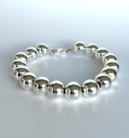 Stelring Silver beaded ball bracelet  on a light gray background. Jolie Esprit