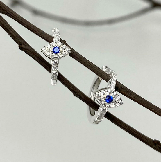 Jolie Esprit Pair of silver earrings with evil eye design on a branch