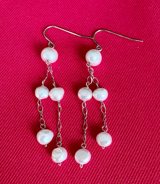 Jolie Esprit pair of pearl earrings on a pink background