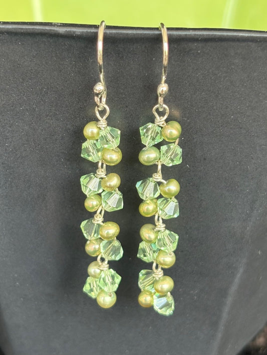 Green beaded earrings on a black background