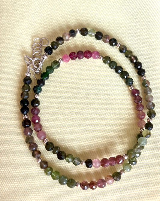 Multicolored watermelon tourmaline gemstone beaded necklace on a beige background. Jolie Esprit