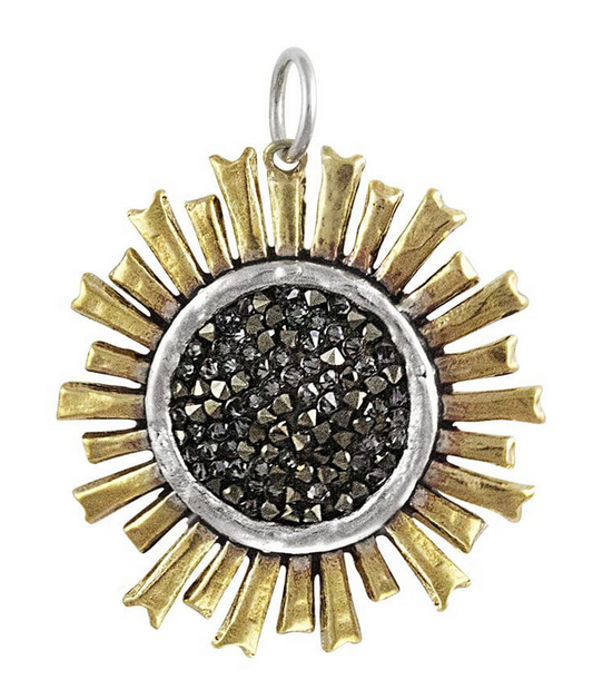 Sun-shaped pendant with gold rays and black swarovski crystal center on a white background
