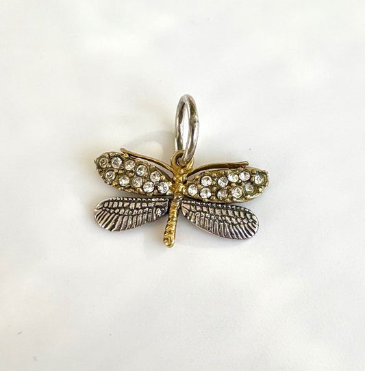 Dragonfly-shaped pendant with gemstones on a white background