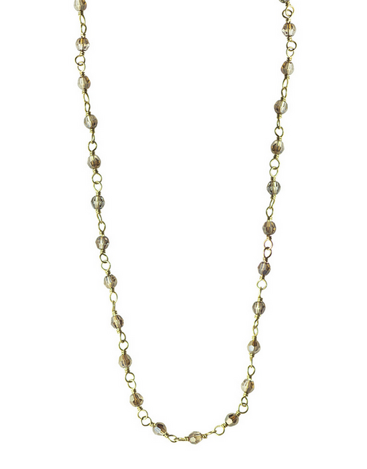 Gold chain necklace with small beads on a white background