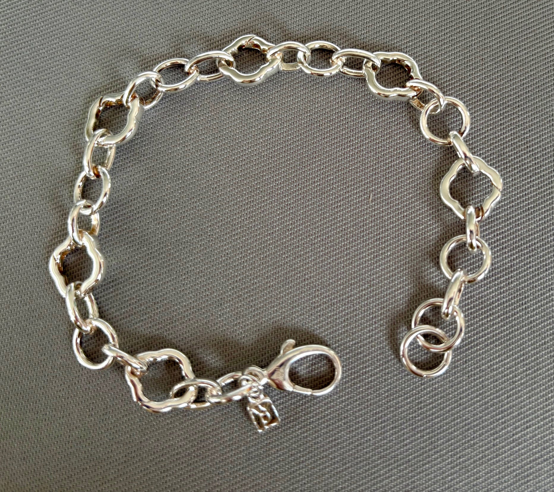 Sterling Silver chain charm bracelet on a gray background