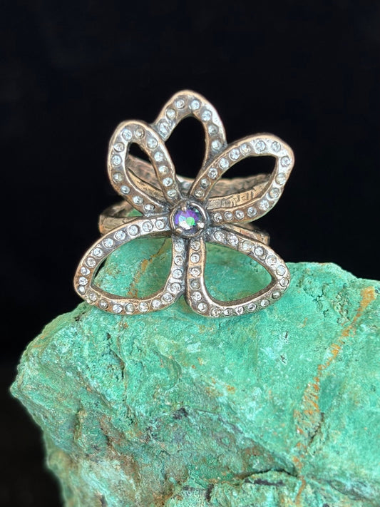 Silver flower-shaped ring with swarovski crystals on a green stone background