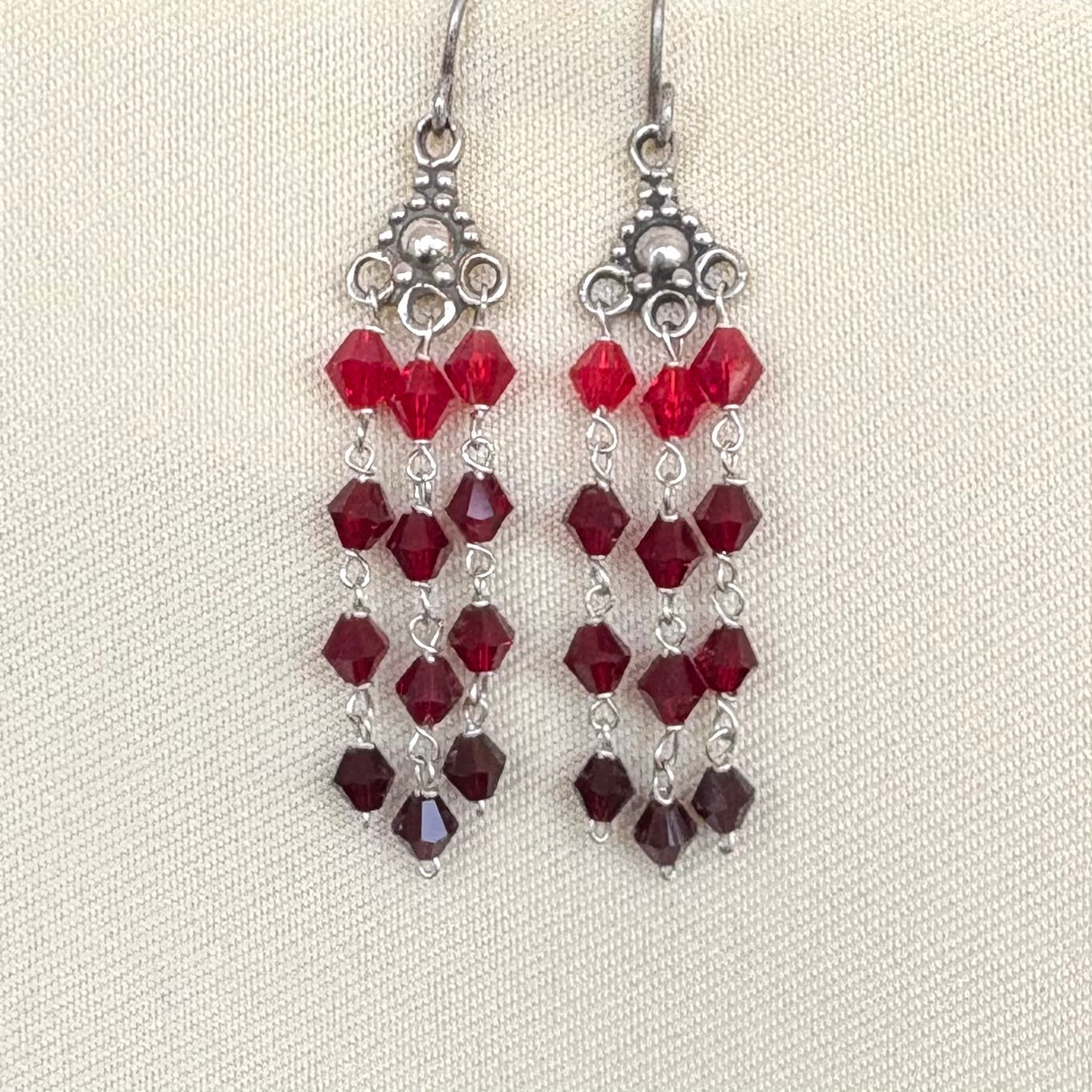 Pair of red beaded earrings on a light background