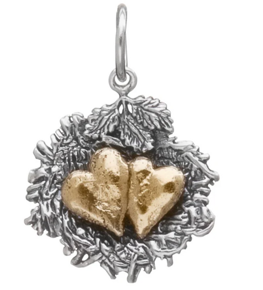 Silver and gold hearts in nest charm in a nest on a white background